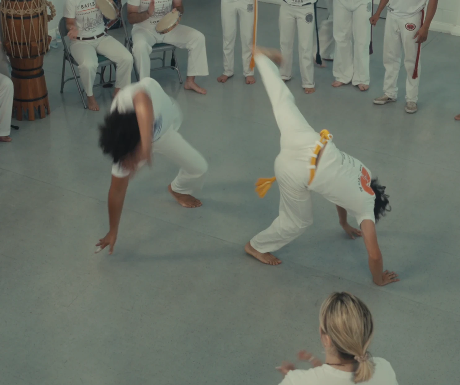 Two capoeiristas moving through cartwheels in the roda