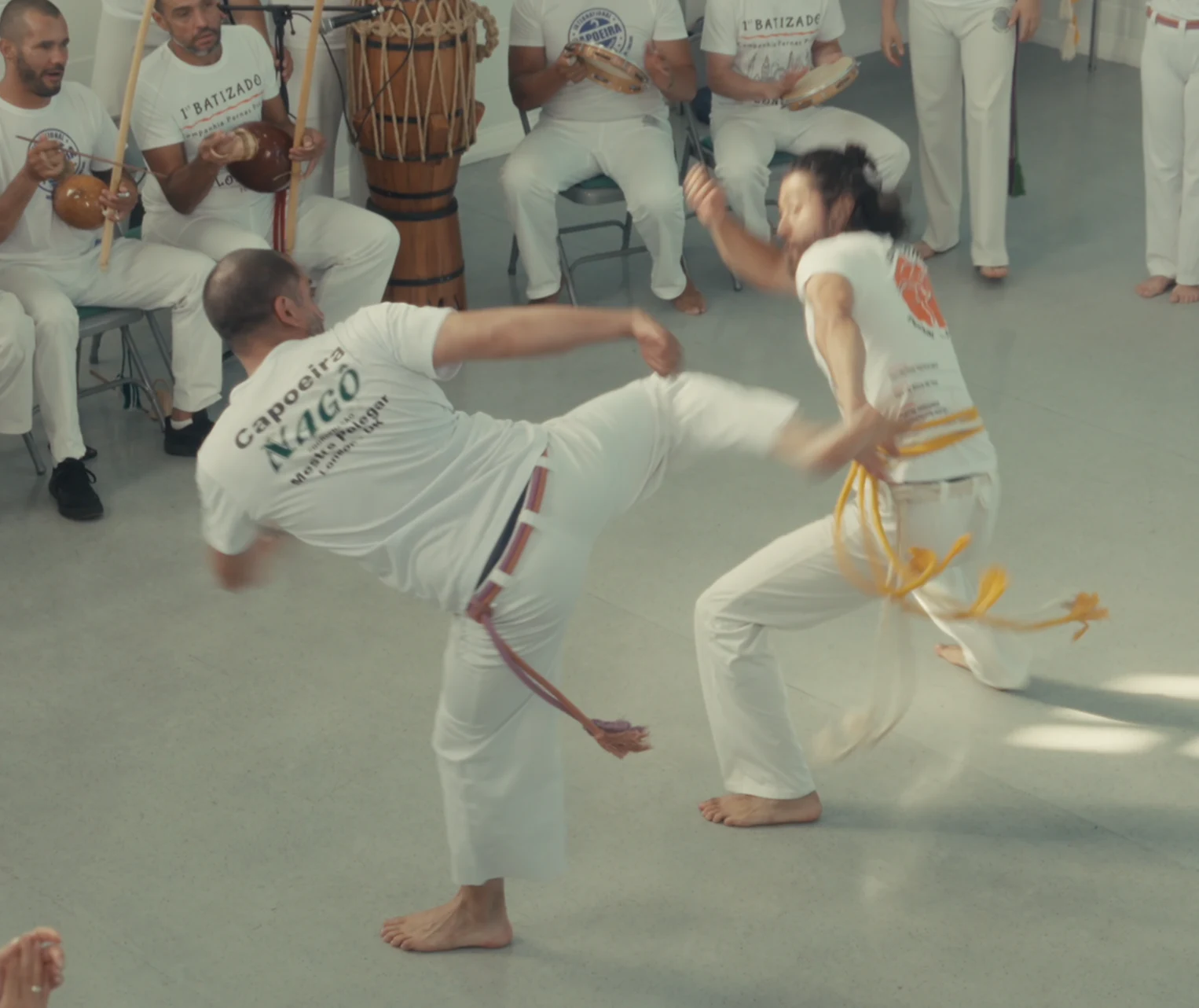 Two capoeiristas exchanging a kick and an evasion