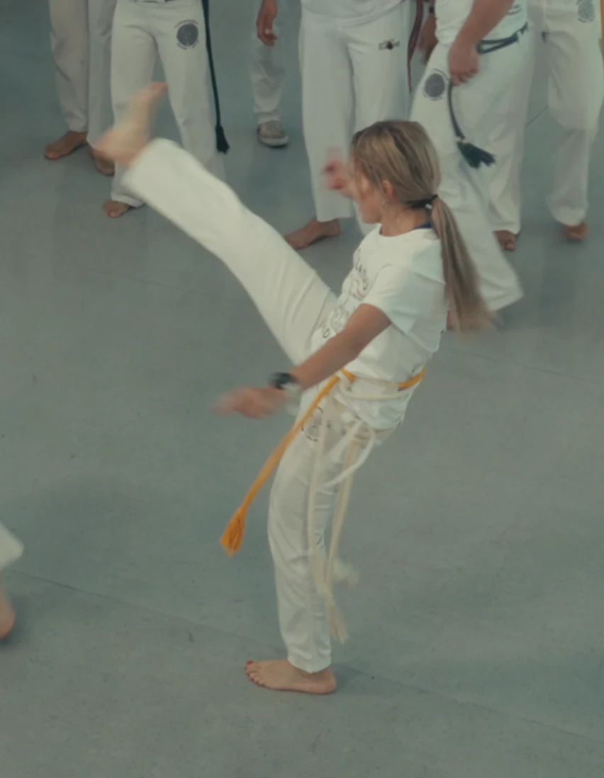 A student with a yellow cord practising a high kick
