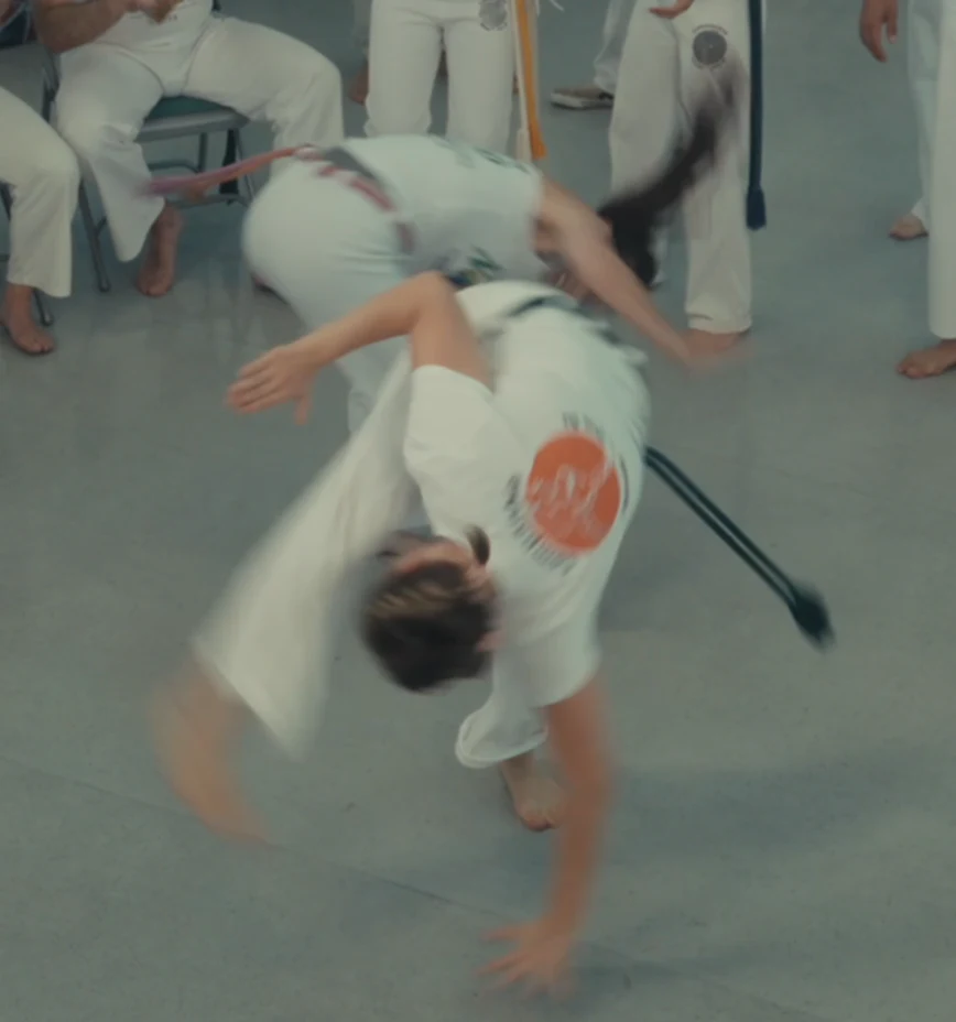 Two capoeiristas turning through flowing movements