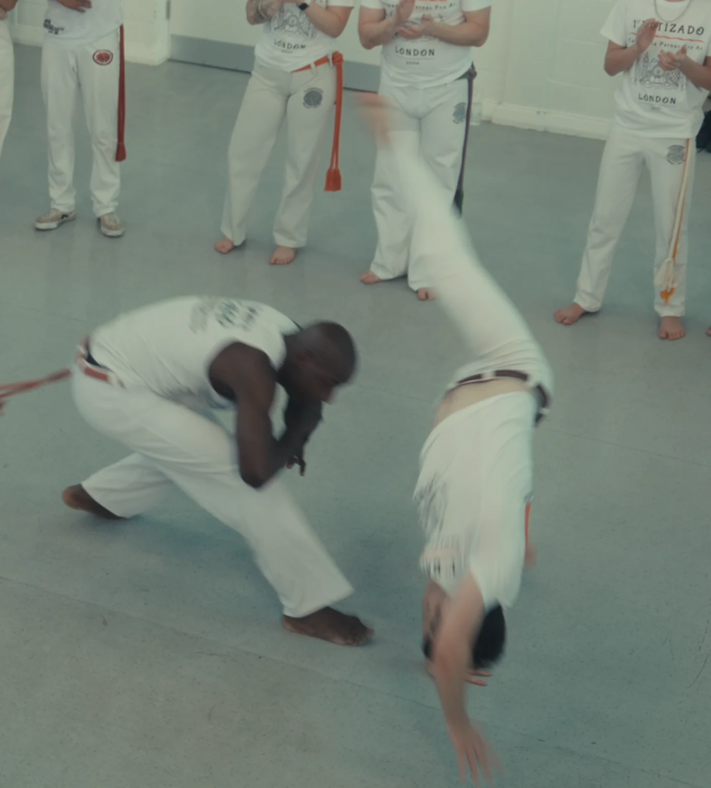 A capoeirista ducking beneath an inverted kick